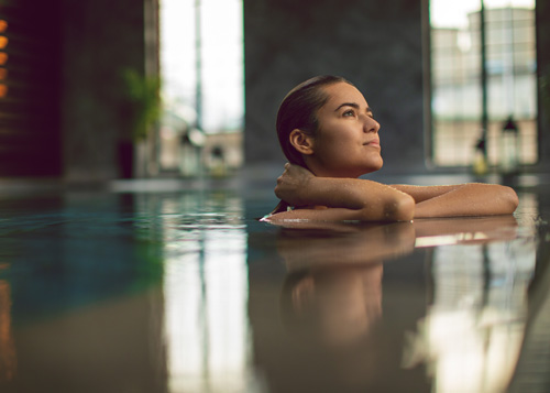 een vrouw geniet van het zwembad in een wellnesscentrum